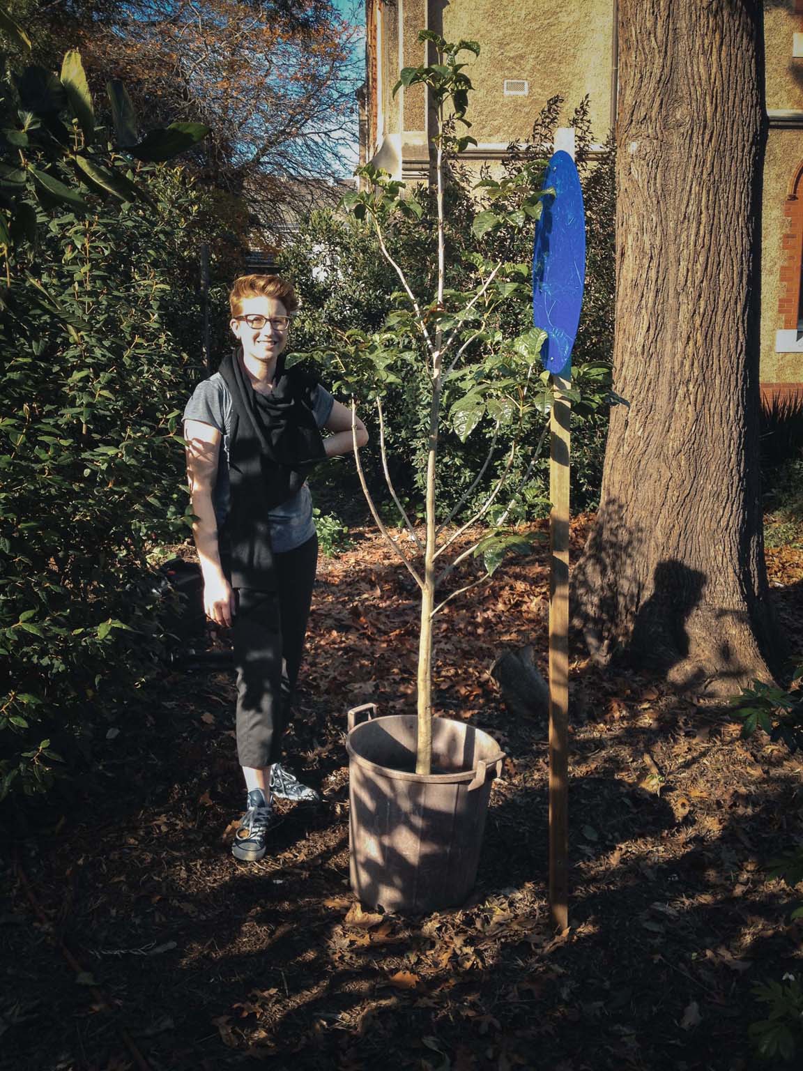 A person standing beside the living tree outdoors in the convent garden