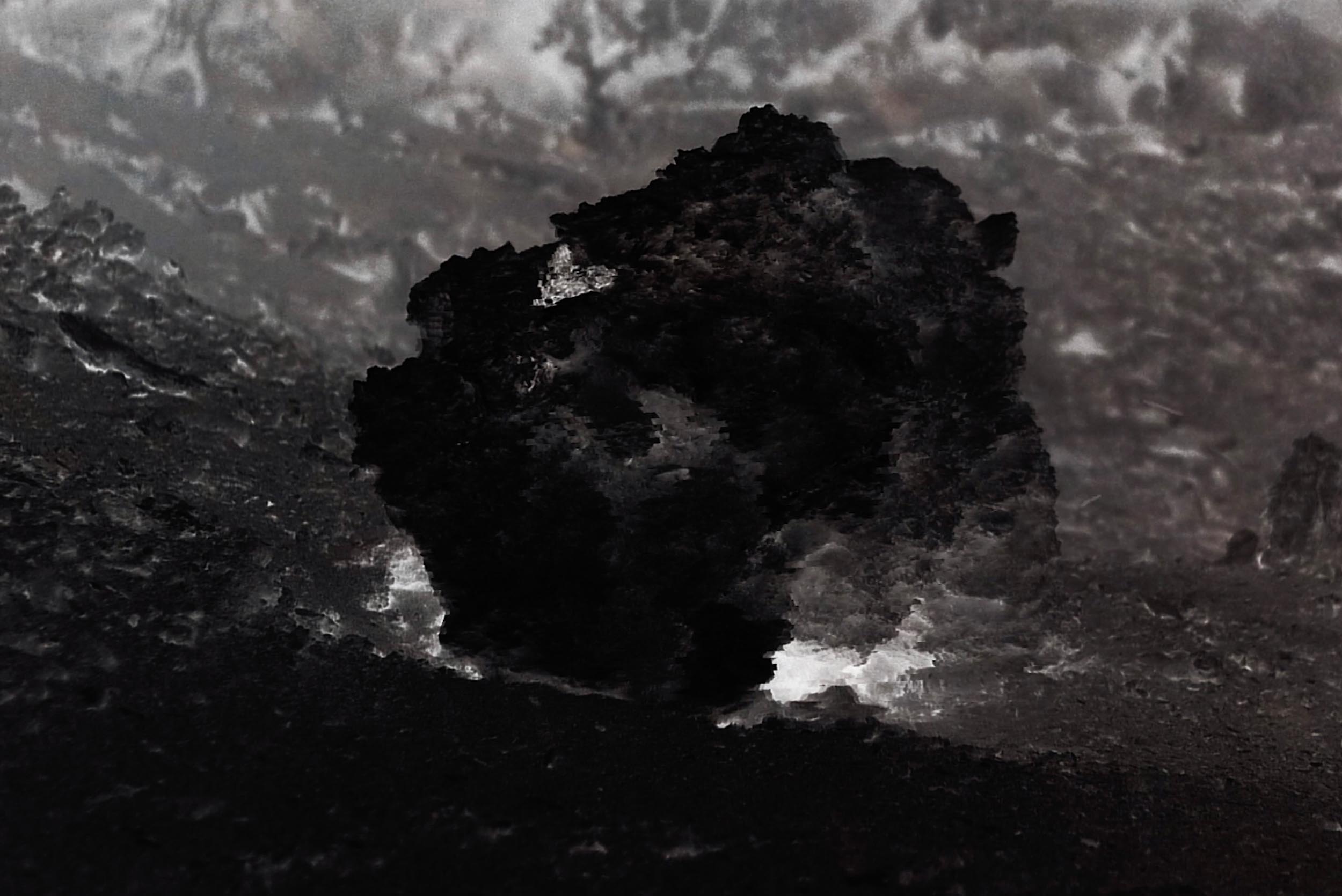 Still from Collider showing a dark abstracted rock form within a monochrome landscape