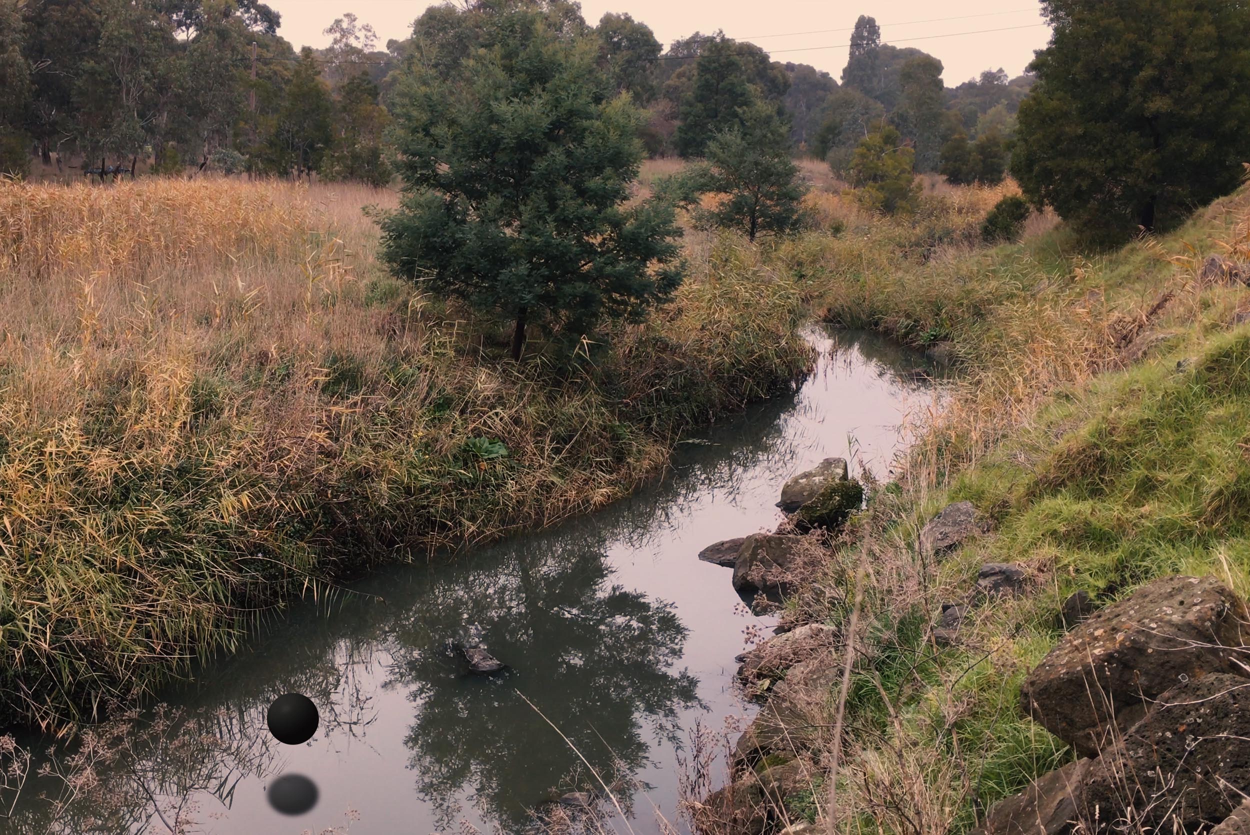 Still from Collider showing Darebin Creek with dark spherical forms reflected in the water