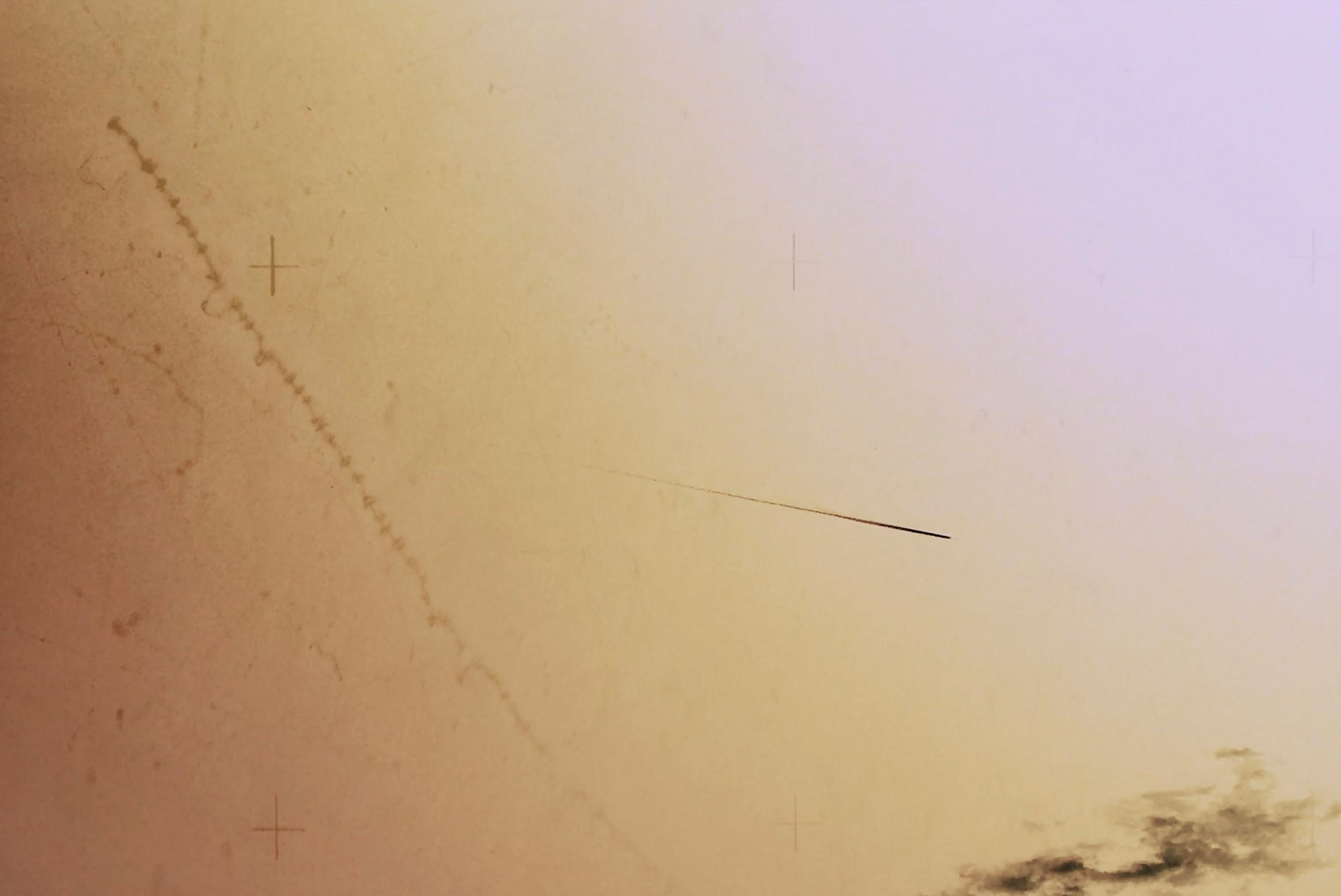 Still from Collider showing fine lines and cross marks across a pale ochre field