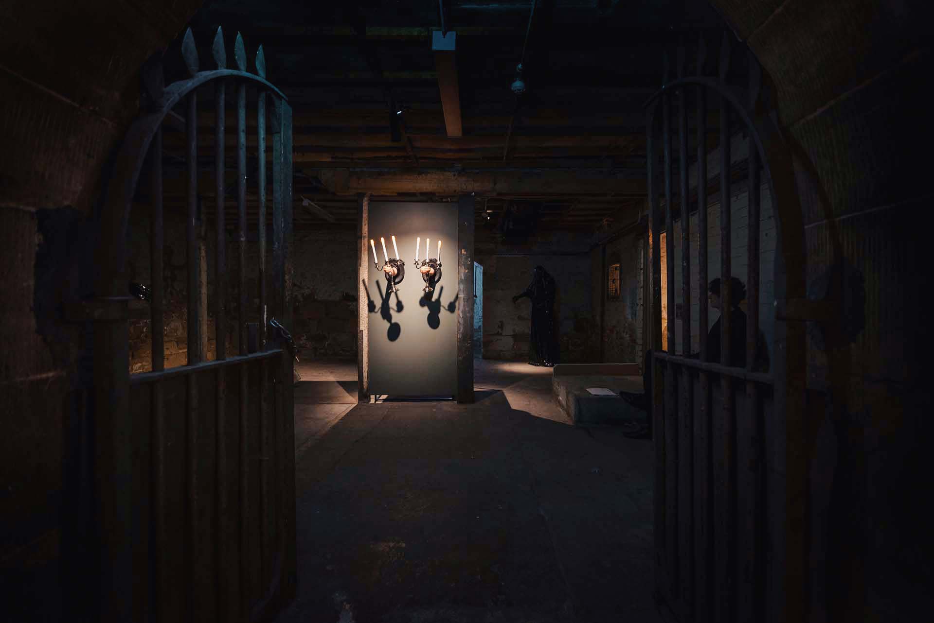Dark underground exhibition space with illuminated sculptural works