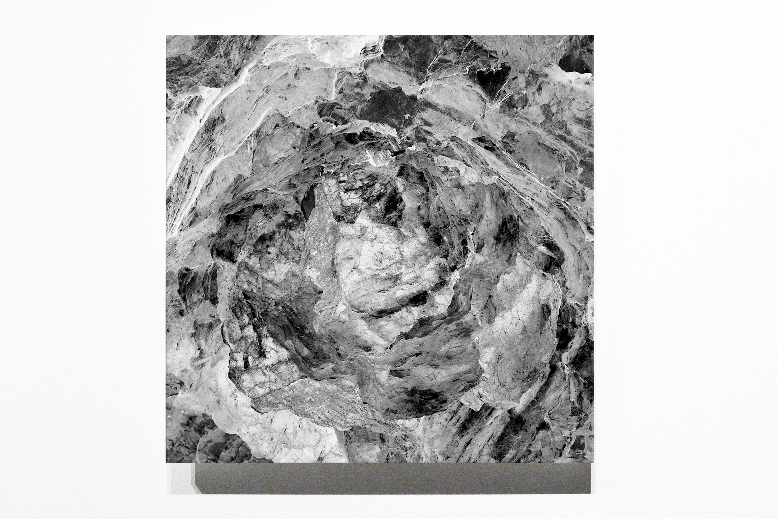 Square black-and-white artwork showing a dense folded material form
