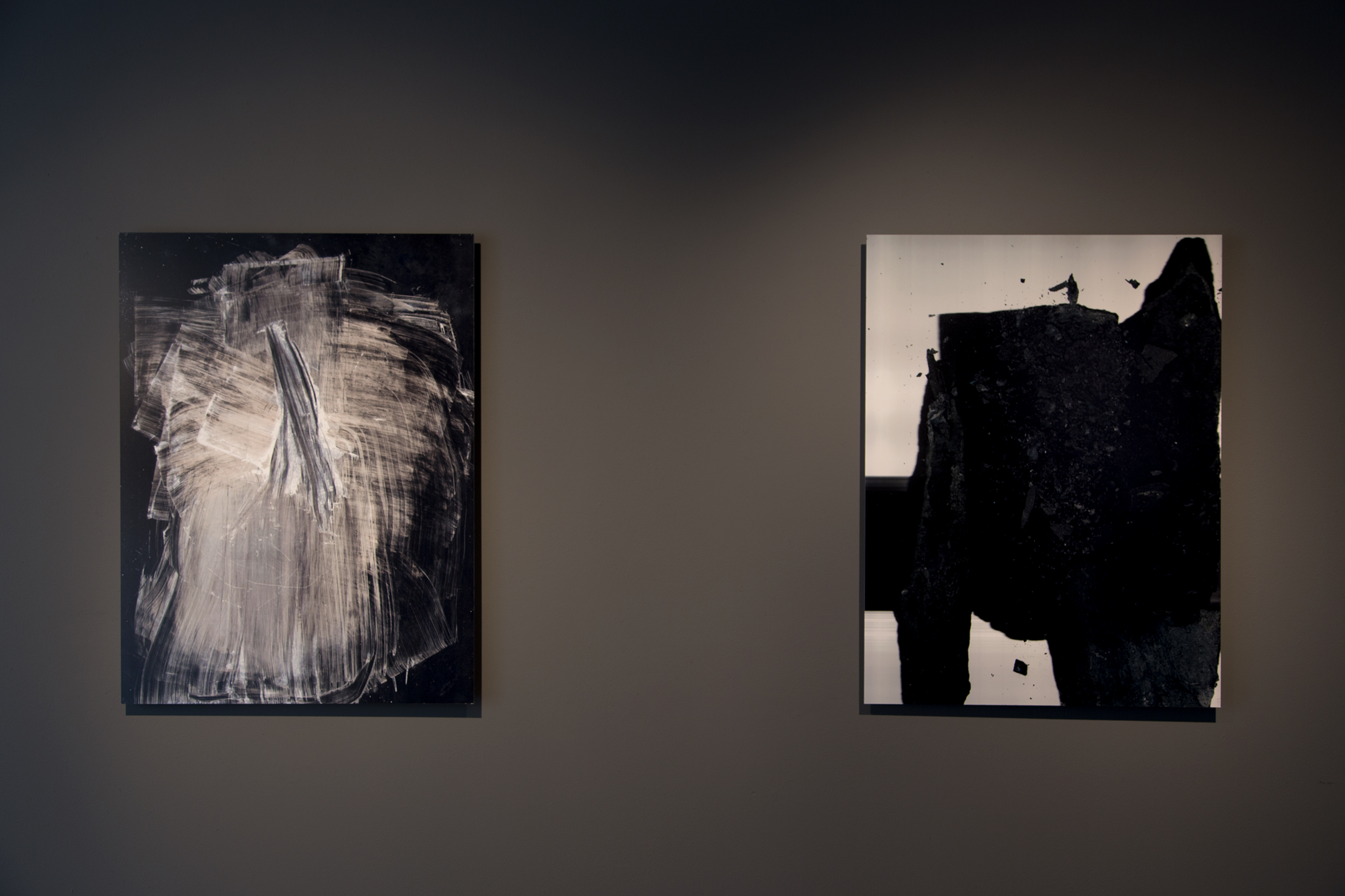 Installation view of two illuminated Fieldcast works on a dark gallery wall