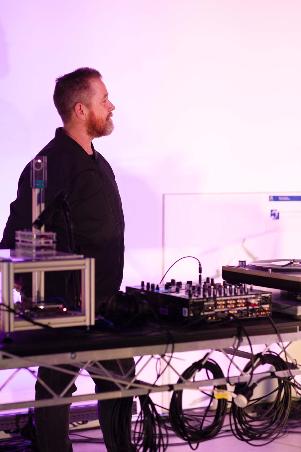 Jon Butt standing behind the μMuography particle detector, turntable and audio equipment