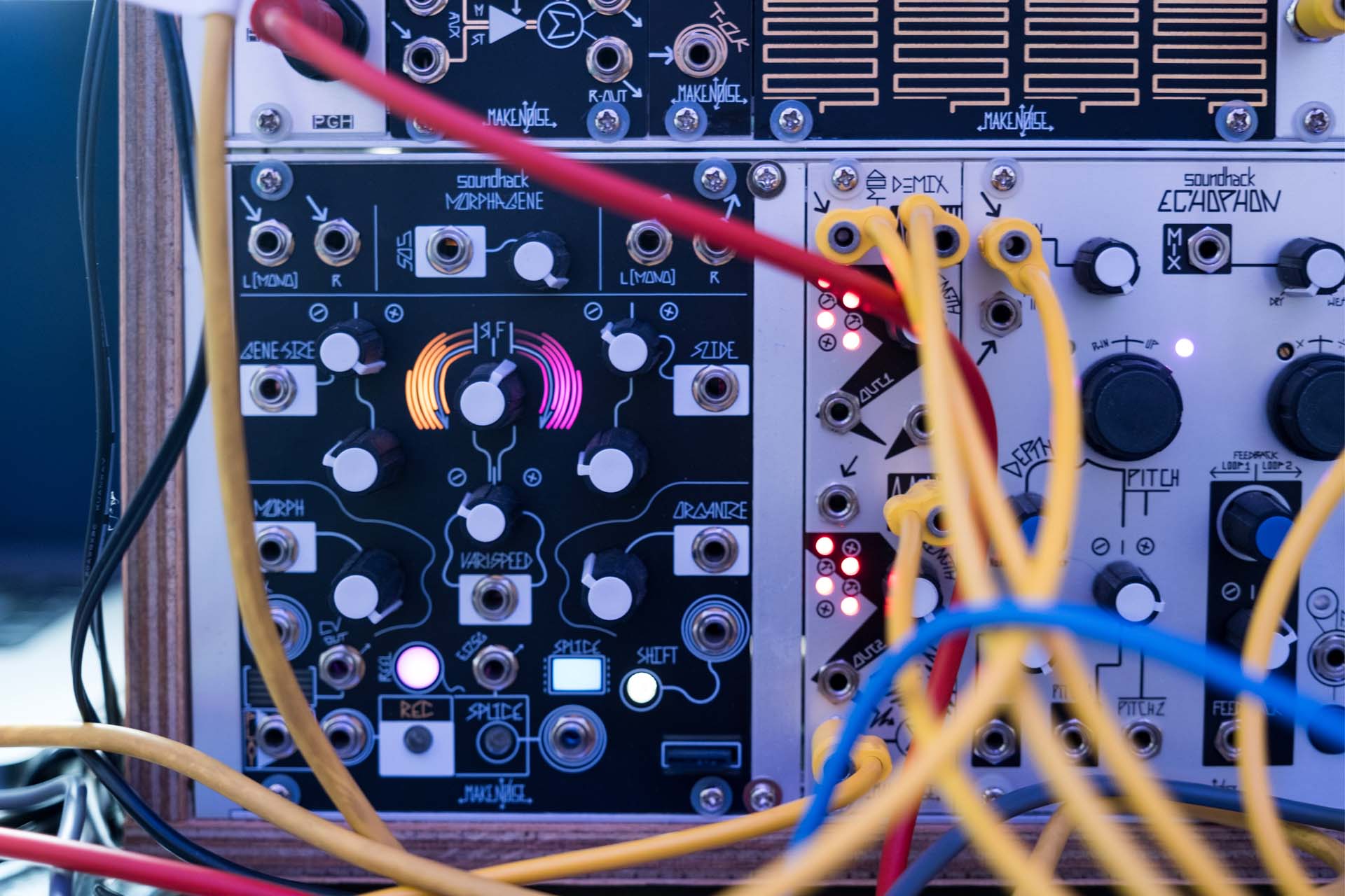 Close view of modular synthesiser controls and patch cables