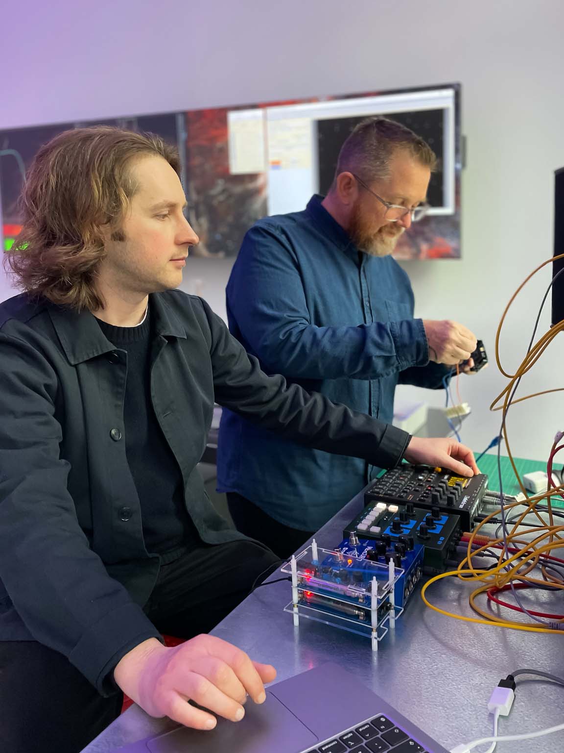 Lewis Gittus and Jon Butt developing sound with the particle detector and electronic instruments