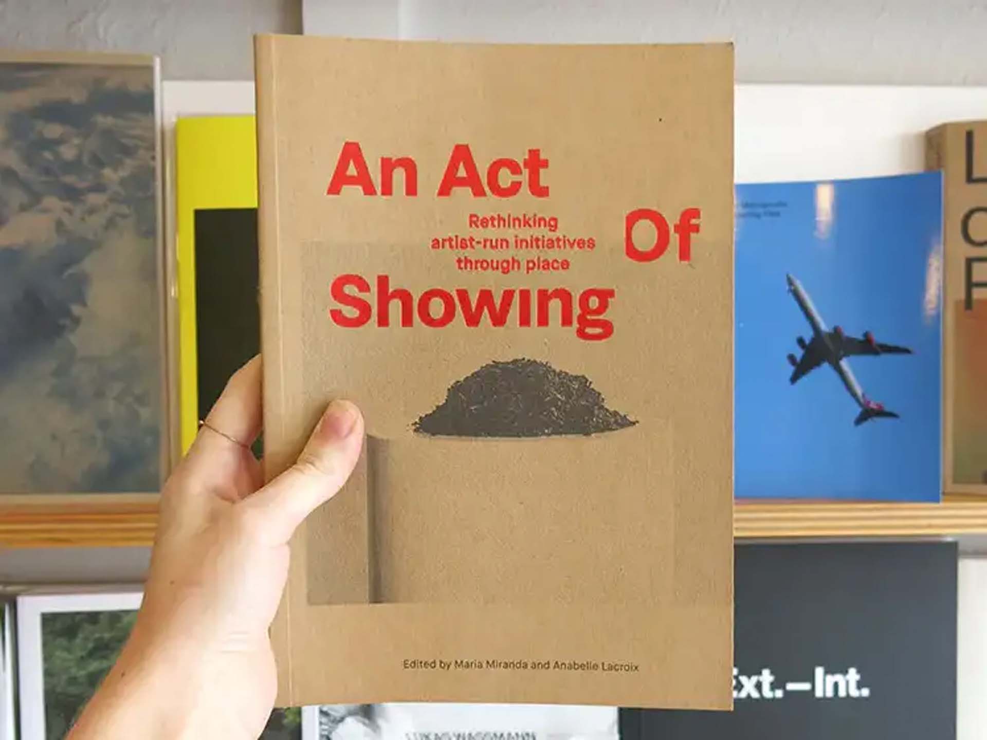 A hand holding the An Act of Showing publication